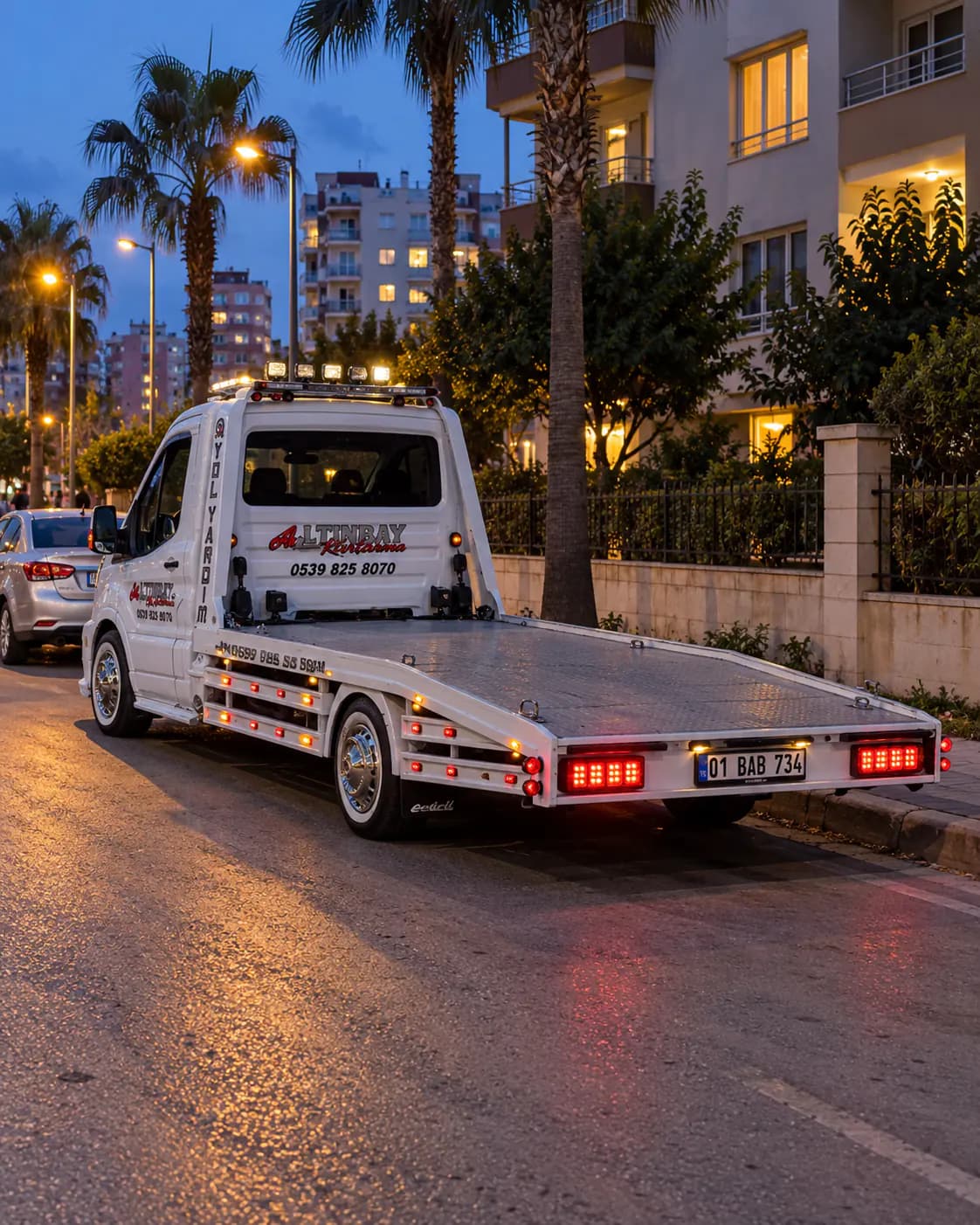 Gece park halindeki otomobilin önünde duran beyaz düz yataklı çekici