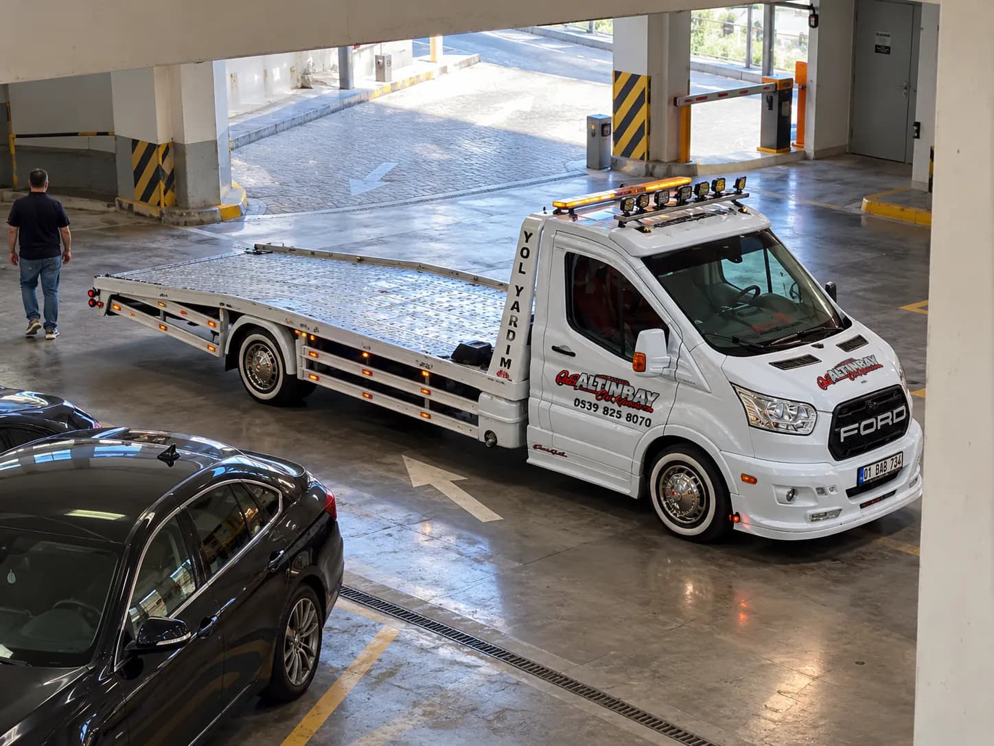 Kapalı otoparkta çekiciye yüklenmeye hazır bekleyen otomobil