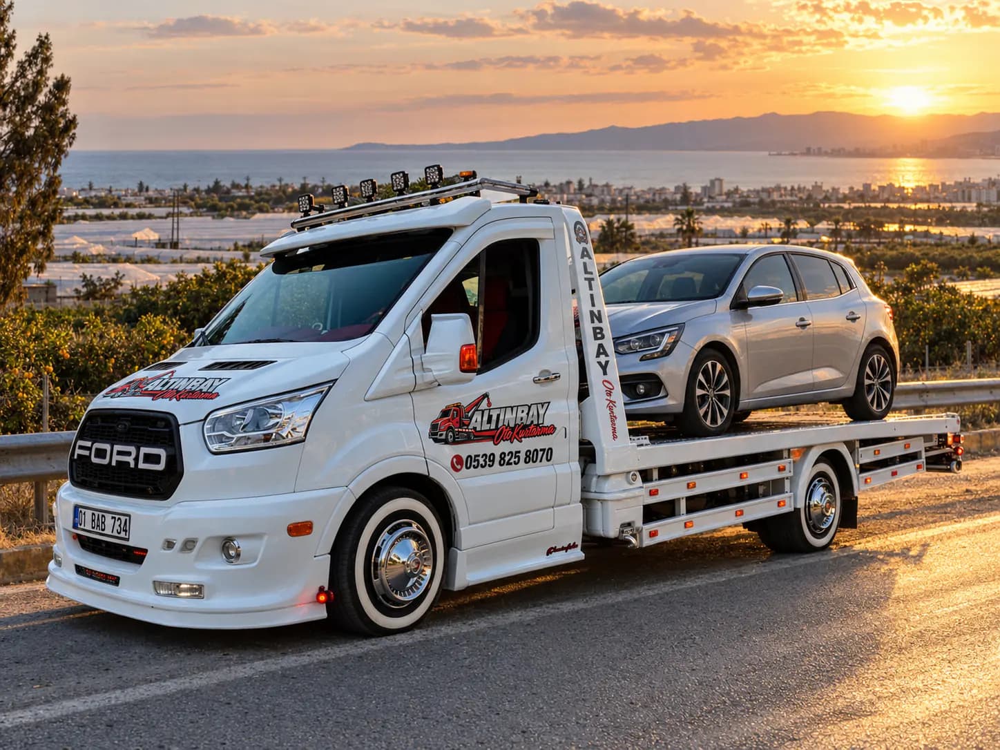 Arızalı bir otomobilin düz yataklı çekiciye yüklenmesi, yol kenarında gün batımı