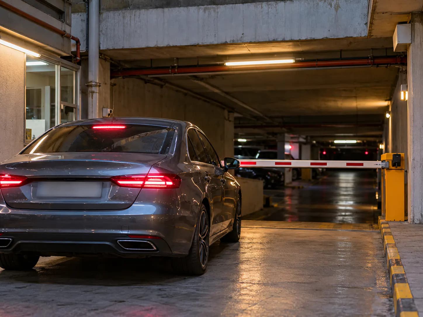 Kapalı otopark girişinde bekleyen otomobil ve bariyer