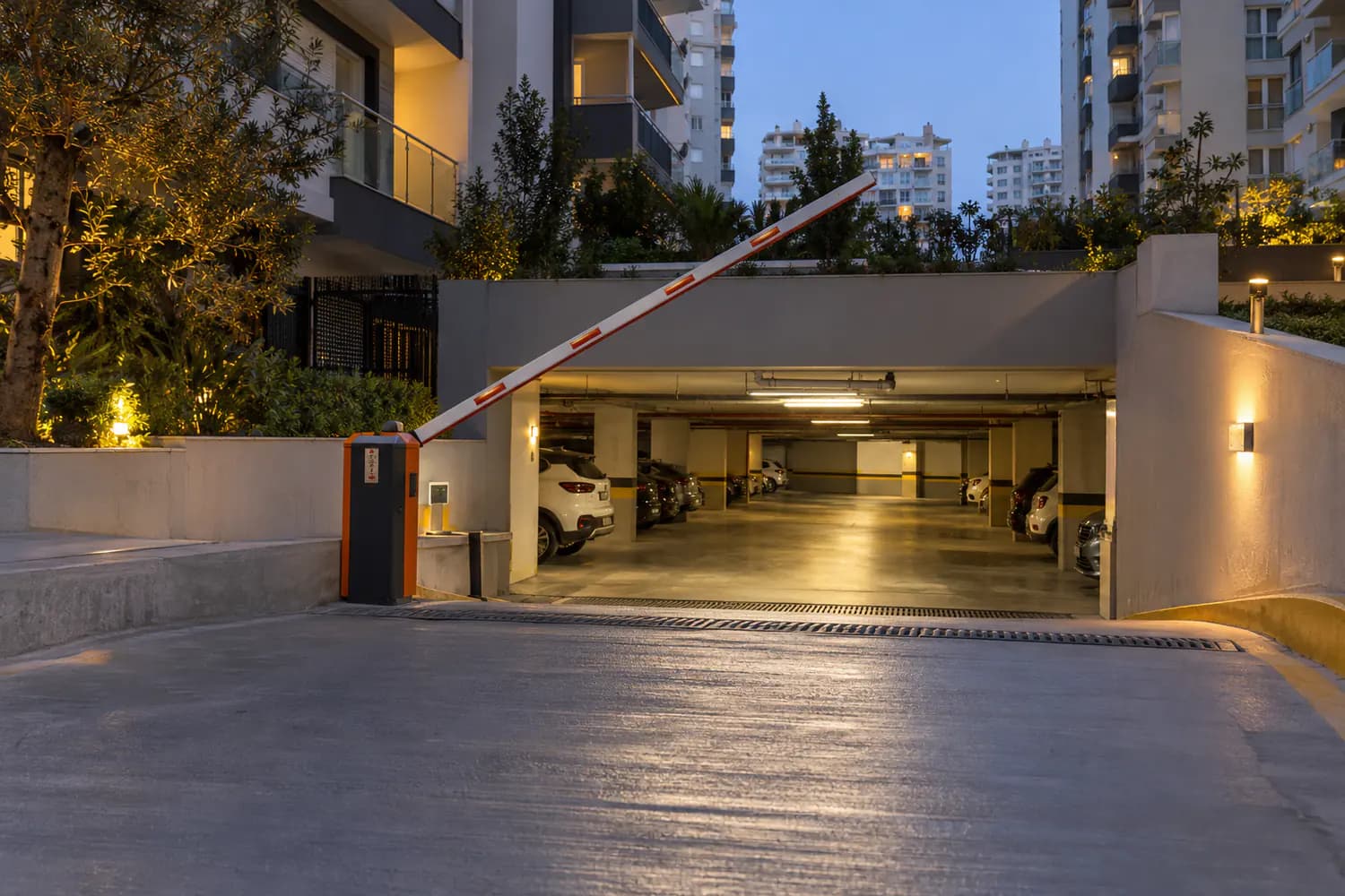 Site girişindeki bariyerli otopark rampası ve içeride park etmiş araçlar